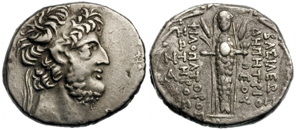 Figura 8: La raffigurazione di Atargatis, velata, dal corpo di pesce, fiancheggiata da steli d'orzo, che porta in mano un fiore sul verso di una moneta di Demetrius III Eucaerus.
